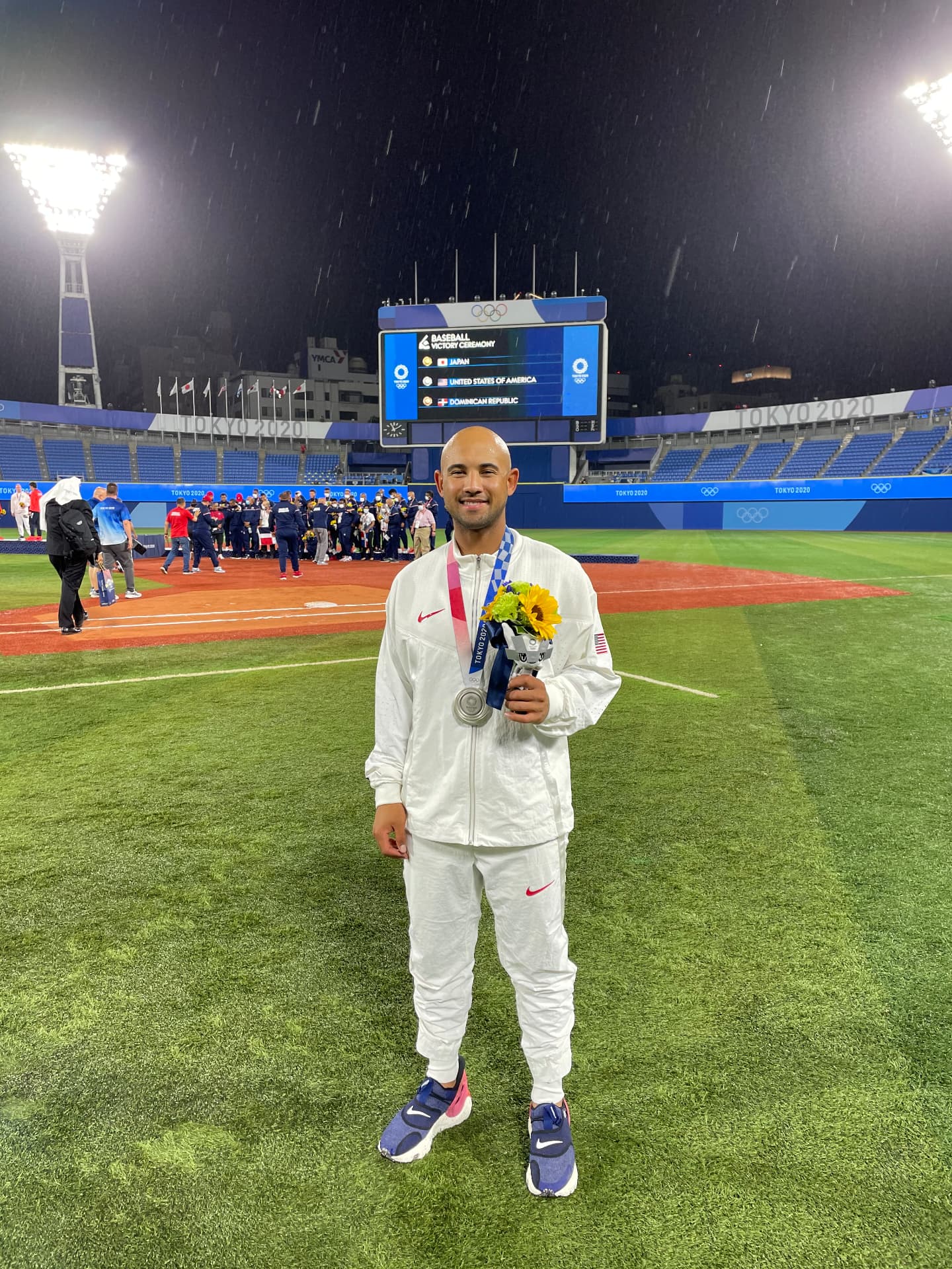 Jamie holding his Olympic silver medal on the field in Tokyo